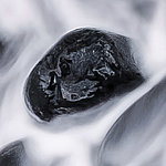 Black stone in rushing water